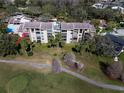 Aerial view of Greenfield Midrises building with balconies on golf course with tree-lined walkway at 13618 Greenfield Dr # 406, Tampa, FL 33618