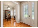 Bright foyer showcasing hardwood floors, a decorative glass front door, and a glimpse into a home office at 2209 Branch Hill St, Tampa, FL 33612