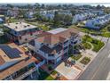 An aerial view shows a large, multi-story home with a driveway and screened balconies, near the beach at 227 126Th Ave, Treasure Island, FL 33706