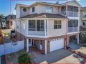 Beautiful multi-story home featuring a covered entryway, a large driveway, screened balconies, and a ground floor garage at 227 126Th Ave, Treasure Island, FL 33706