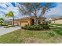 Charming tan single-story home with a well-manicured lawn and lush landscaping, showcasing its inviting curb appeal at 2313 Nottingham Greens Dr # 2313, Sun City Center, FL 33573