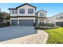 Two-story home with a three-car garage, lush lawn, and stone walkway leading to the front door at 23958 Terracina Ct, Land O Lakes, FL 34639