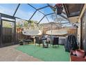 Relaxing screened patio with outdoor furniture, grill, and surfboards at 2612 6Th Ct, Palm Harbor, FL 34684