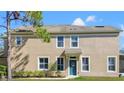 Inviting townhome featuring a teal front door, manicured lawn, and a cozy covered entrance at 2824 Conch Hollow Dr, Brandon, FL 33511
