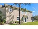 Charming townhome with a covered front entry and a teal-colored door surrounded by well-manicured landscaping at 2824 Conch Hollow Dr, Brandon, FL 33511