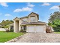 Charming two-story home with a brick driveway, three-car garage, and lush landscaping at 3018 N 164Th Pl, Clearwater, FL 33760