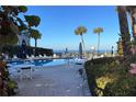A serene pool area, set against an ocean backdrop, offers lounge seating and sun umbrellas at 3400 Gulf Blvd # 304, Belleair Beach, FL 33786