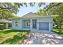 Inviting light blue single-story home with a well-maintained front yard and a convenient attached garage at 3409 E 11Th Ave, Tampa, FL 33605