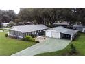 Features a home with a detached garage and patio area for outdoor enjoyment at 38055 Avion Dr, Zephyrhills, FL 33542