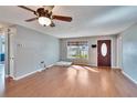 Comfortable living area with hardwood floors, large window for natural light, and fan at 415 Maplewood Cir, Oldsmar, FL 34677