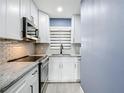 Modern kitchen with white cabinets, stainless steel appliances, and stylish backsplash at 4570 Overlook Ne Dr # 282, St Petersburg, FL 33703