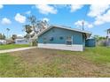 Single story home with teal siding and white painted foundation, with an adjacent covered parking area at 4638 Heavens Way, New Port Richey, FL 34652