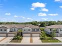 Community view of townhomes with 2 car garages, landscaping, and ample parking at 5994 Shiner St, Land O Lakes, FL 34638
