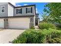 Stylish townhome featuring a two-car garage, stone accents, and lush greenery at 5994 Shiner St, Land O Lakes, FL 34638