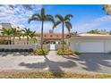 Beautiful two-story home with a manicured front yard, palm trees, and a tiled roof, offering classic curb appeal at 611 Brightwaters Ne Blvd, St Petersburg, FL 33704