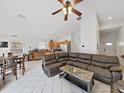 Open-concept living room with tile floors, ceiling fan, kitchen, and dining space at 6512 N 24Th St, Tampa, FL 33610