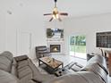 Bright living room featuring a fireplace, sliding doors, and a ceiling fan at 6512 N 24Th St, Tampa, FL 33610