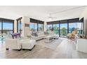 Bright living room featuring a comfortable white sofa, expansive windows, and beautiful views at 9525 Blind Pass Rd # 301, St Pete Beach, FL 33706
