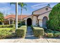 Charming home featuring a meticulously manicured front lawn with manicured bushes leading to a welcoming front entrance at 1008 Royal Birkdale Dr, Tarpon Springs, FL 34688