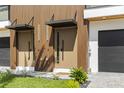 Up close, a modern townhome entrance with a unique wood exterior and stone paver driveway at 101 W Warren Ave # 1, Tampa, FL 33602