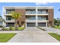 View of townhomes boasting private balconies and attached garages, framed by lush greenery and a clear blue sky at 101 W Warren Ave # 1, Tampa, FL 33602