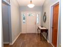Welcoming foyer with wood floors, front door, and table at 11722 Currie Ln # G1, Largo, FL 33774