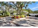 Community entrance with mature trees, tropical landscaping and guard house at 1324 Pasadena S Ave # 204, South Pasadena, FL 33707