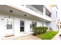 Two story condo building featuring white siding and a grassy lawn with unit entrances at 2100 World Parkway Blvd # 30, Clearwater, FL 33763