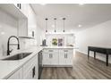Bright kitchen with white cabinets, stainless steel appliances, and pendant lighting at 2101 Cordova Grn, Seminole, FL 33777