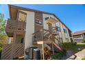 Corner view of a condo featuring exterior staircases, dual balconies, and dual air conditioning units at 2364 Flanders Way # 41-D, Safety Harbor, FL 34695
