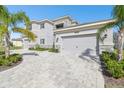 Impressive two-story home featuring a three-car garage, stone details, and paved driveway at 3280 Juniper Springs St, Wesley Chapel, FL 33543