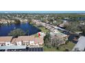 Aerial view of condo community, pond, and community pool with beautiful landscaping at 3857 Sailmaker Ln, Holiday, FL 34691