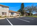 Well-maintained condo exterior with mature landscaping, assigned parking and blue skies at 3857 Sailmaker Ln, Holiday, FL 34691