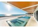 An inviting in-ground pool and jacuzzi with ocean views and a covered patio area at 4005 Casey Key Rd, Nokomis, FL 34275
