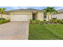 Charming single-story home featuring a well-manicured lawn, paver driveway, two-car garage, and beautifully landscaped front yard at 42211 Edgewater Dr, Punta Gorda, FL 33982
