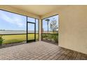 Relaxing screened patio featuring brick pavers, offering a tranquil view of the lake and lush landscaping at 42211 Edgewater Dr, Punta Gorda, FL 33982