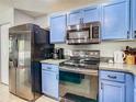 Stylish kitchen with stainless steel appliances, blue cabinets, and modern countertops at 4441 Fieldview Cir, Wesley Chapel, FL 33545