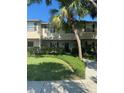 Well-maintained townhome with tan facade, dark shutters, and a lush green lawn and manicured bushes at 5231 Bayshore Blvd # 10, Tampa, FL 33611