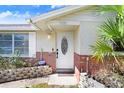 Close up of the front door and entryway with brick accents and attractive landscaping at 5510 Berlin Dr, Port Richey, FL 34668