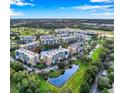Aerial of the condo community showcasing lush greenery, water views, and ample parking at 960 Starkey Rd # 3406, Largo, FL 33771