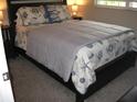 Comfortable bedroom with a cozy bed featuring decorative pillows and bedding, and a window at 9911 Dahlia N St # 38, Pinellas Park, FL 33782