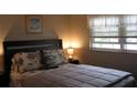 Comfortable bedroom with a cozy bed featuring decorative pillows and bedding, and a window at 9911 Dahlia N St # 38, Pinellas Park, FL 33782