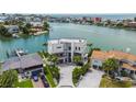 Expansive aerial view of a waterfront home boasting modern architecture, lush landscaping, and a private driveway at 10100 Tarpon Dr, Treasure Island, FL 33706