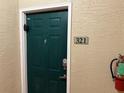 The front door of unit 321, equipped with a digital lock and peephole, next to a fire extinguisher at 1216 S Missouri Ave # 321, Clearwater, FL 33756