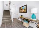 Charming entryway with staircase, tiled floor, beach art, console table, and decorative lighting at 125 Shoals Cir, North Redington Beach, FL 33708