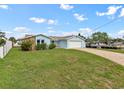 Single-story home with a two-car garage, stone accents, and a well-manicured lawn at 13437 Lisa Dr, Hudson, FL 34667