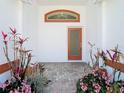 Inviting front entryway with decorative plants and pathway, creating a warm welcome at 13542 Norman Cir, Hudson, FL 34669