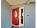 Close-up of a vibrant red front door with decorative glass and modern security features at 1425 Monte Lake Dr, Valrico, FL 33596