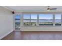 Living room featuring wood floors, a large window with a view of the water and waterfront patio at 19029 Us Highway 19 N # 17A, Clearwater, FL 33764
