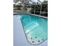 Screened-in pool features crystal-clear water and a tiled border, creating a refreshing outdoor oasis at 2510 Cypress Bend E Dr, Clearwater, FL 33761
